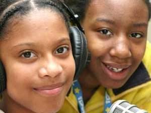 two students sitting in front of radio microphone