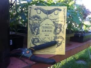 An almanac on a table surrounded by starter plants