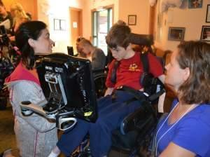 Speech-language pathologists Jill Tullman (left) and Mendi Carroll (right) work with Bryce Vernon at Talking with Technology Camp in Empire, Colo., on July 25.