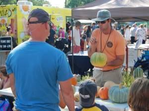 A man holding a squash talking to children.