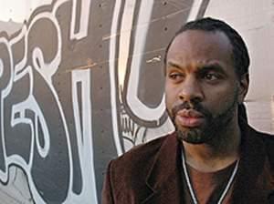 Byron Hurt standing by graffiti covered wall