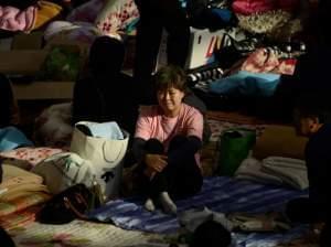 A relative sits in a gym in South Korea to await news.