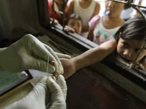 A health official takes a blood sample from a child's finger for a malaria test at a clinic in Bong Ti Lang village on the Thai-Myanmar border.