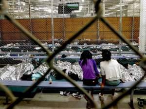 Two young girls, part of the wave of unaccompanied children who've illegally entered the U.S., watch a soccer match at the Customs and Border Protection Nogales Placement Center in Arizona.