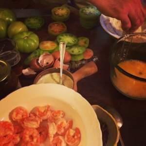 A kitchen counter with green tomatoes and other ingredients