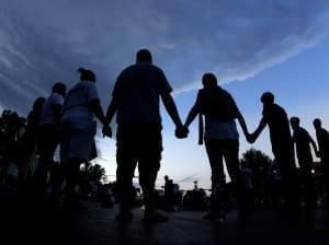 People stand in prayer August 20th in Ferguson August 20th. 