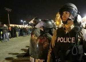 Police watch the protesters gather Tuesday in Ferguson.