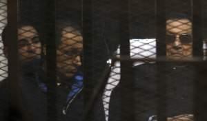 Mubarak lies on a gurney next to his son Gamal in the defendants cage, during a court hearing in Cairo