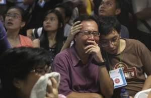 Relatives of passengers of the missing AirAsia flight react to news on television. 