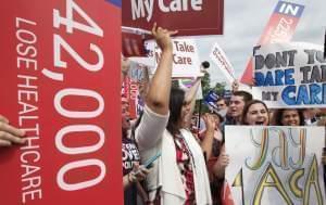 Jessica Ellis, right, with "yay 4 ACA" sign, and other supporters of the Affordable Care Act, react with cheers as the opinion for health care is reported outside of the Supreme Court in Washington Thursday. 