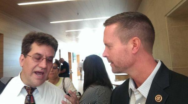 Robert Naiman of the the C-U Move On chapter presents a petition to Congressman Rodney Davis Friday at the Champaign Public Library.