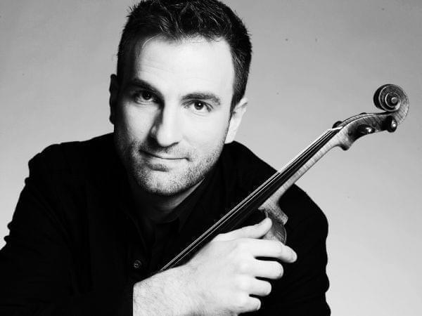 A man posing with a violin