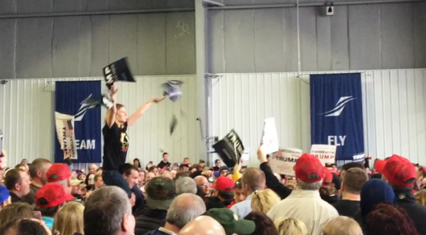 A protester tears up a Trump poster at Donald Trump's campaign rally in Bloomington