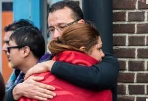 People comfort each other after being evacuated from Brussels airport, after explosions rocked the facility in Brussels, Belgium, Tuesday March 22, 2016. 