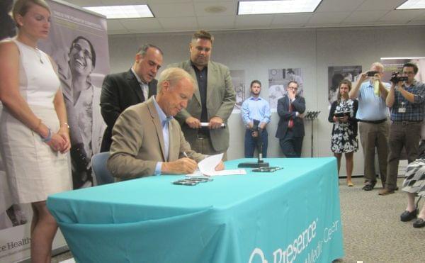 Gov. Bruce Rauner signing legislation.