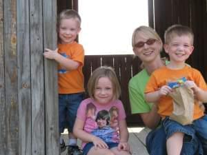 Mother, twin boys, and little girl smiling