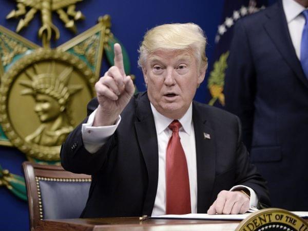 President Donald Trump signs executive orders in the Hall of Heroes at the Department of Defense on Friday in Arlington, Va. 