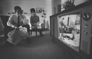 An American man and woman watching footage of the Vietnam War on television in their living room, February 1968