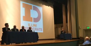 Candidates and moderator on stage for a candidates forum.