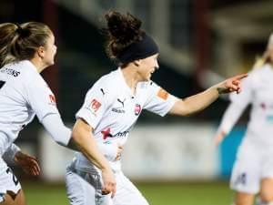 woman soccer player points at teammate