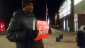 Man holding sign demanding strict gun control legislation