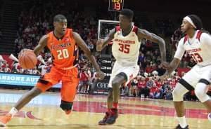 Illinois' Damonte williams drives against Rutgers defenders Issa Thiam (35) and Deshawn Freeman