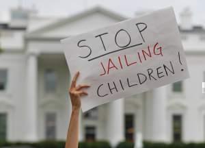 A demonstrator holds up a sign during a rally opposed to President Trump's family separation policy