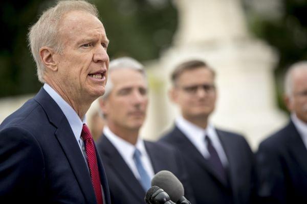 Illinois Gov. Bruce Rauner, left, accompanied by Liberty Justice Center founder and chairman John Tillman, second from left, and Liberty Justice Center's Director of Litigation Jacob Huebert, right, speaks outside the Supreme Court after the cou