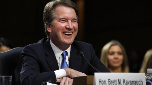 Supreme Court nominee Brett Kavanaugh laughs as closing remarks are made Wednesday evening after the second day of his confirmation hearings before a Senate panel on Capitol Hill in Washington, D.C., to replace retired Justice Anthony Kennedy.