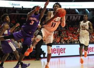 Illini freshman Ayo Dosunmu maneuvers the ball past Evansville's Jawaun Newton.
