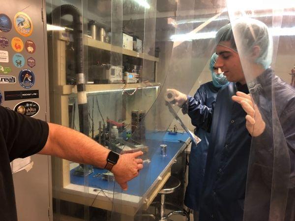 University of Illinois engineering student Adam Newhouse holds a spool of the type of lightweight material used on the CubeSail satellite. 