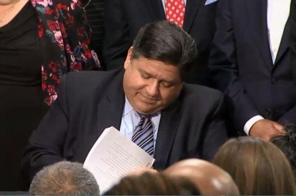 Gov. JB Pritzker signs gun dealer licensing measures at a ceremony in Chicago on Jan. 17.