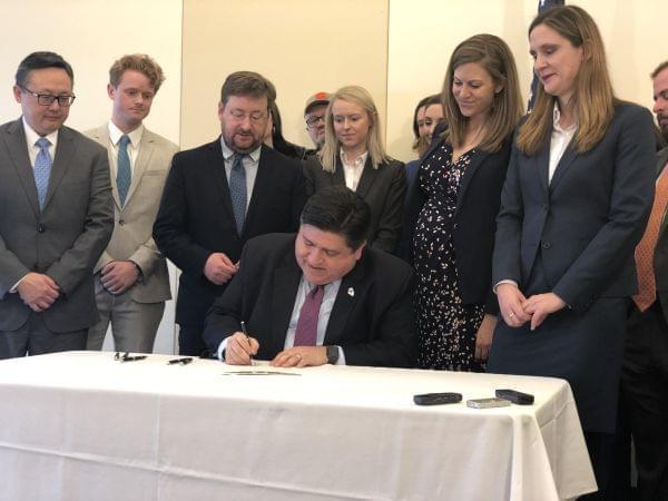 Surrounded by environmental advocates, Gov. J.B. Pritzker signs and executive order making Illinois the 18th state to join the U.S. Climate Alliance on January 23, 2019. 