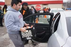 Volunteers load surplus milk purchased by the USDA into cars at a special distribution day in St. Louis.