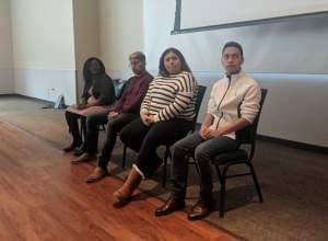 Four young people sitting down in a conference room to talk about their experience as homeless unaccompanied youth.