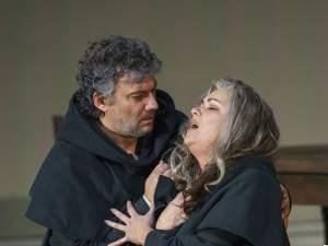 Man and woman embrace on stage.