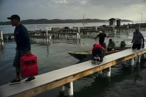 People arrive to a private harbor to move boats away for protection ahead of the arrival of Tropical Storm Dorian in Boqueron, Puerto Rico, Tuesday, Aug. 27, 2019.