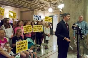 The Thomas More Society's Peter Breen joins a group protesting the signing of the Reproductive Health Act in Chicago in June.