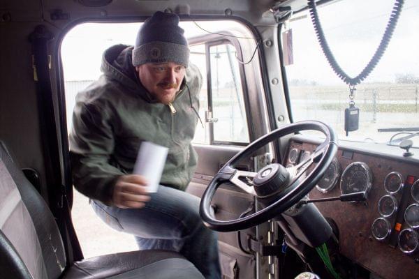 Central Iowa farmer Corey Hillebo climbs into the cab of his semi after picking up the receipt for corn he delivered to a grain elevator.