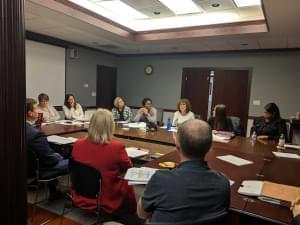 Champaign Unit 4 School Board members and other officials seated around a table in a conference room at one of the district's offices. 