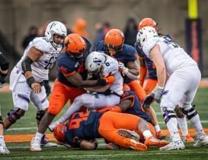 Illinois defenders bring down Northwestern running back Drake Anderson Saturday at Memorial Stadium in Champaign.