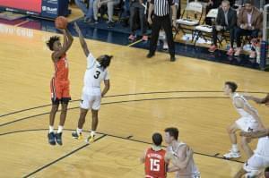 Ayo Dosunmu hits the game-winning shot over Michigan's Zavier Simpson in a 64-62 win on Saturday in Ann Arbor.