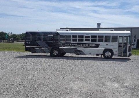 A school bus on a gravel parking lot