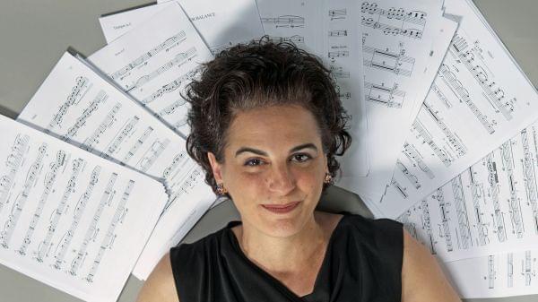 woman lays on top of sheets of music