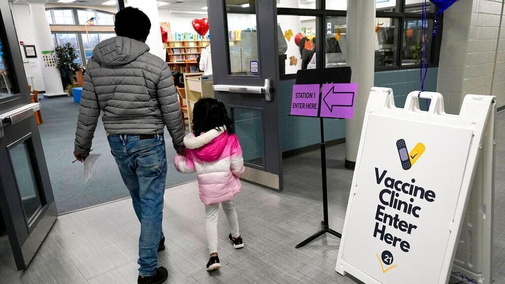 A child arrives with her parent to receive the Pfizer COVID-19 vaccine for children 5 to 11-years-old at London Middle School in Wheeling, Ill., Nov. 17, 2021. As of Tuesday, Jan. 11, 2022, just over 17% of children in the U.S. ages 5 to 11 were fully vaccinated, more than two months after shots for them became available.