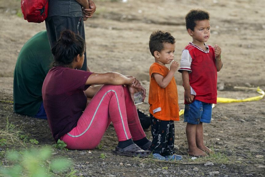 Migrants wait to be processed by the Border Patrol after illegally crossing the Rio Grande river from Mexico into the U.S. at Eagle Pass, Texas, Friday, Aug. 26, 2022. The area has become entangled in a turf war between the Biden administration and Texas Gov. Greg Abbott over how to police the U.S. border with Mexico.