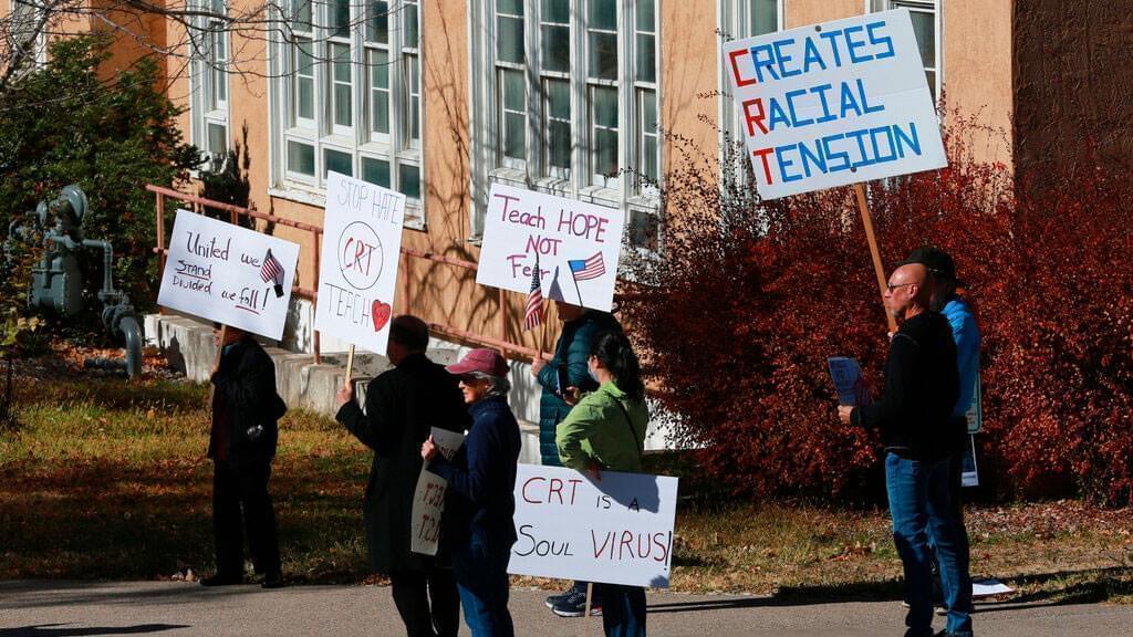 People protest outside the offices of the New Mexico Public Education Department's office, Friday, Nov. 12, 2021, in Albuquerque, New Mexico. The education department proposed changes to the social studies curriculum that critics describe as a veiled attempt to teach critical race theory. Supporters say the new curriculum, which includes ethnic studies, is 