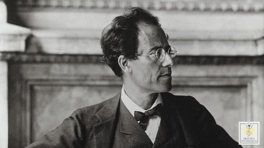 A black and white picture of Gustav Mahler wearing a suit and glasses.