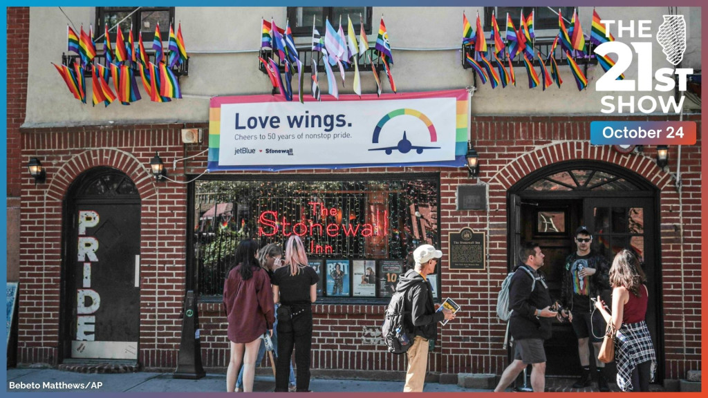 people who appear to be tourists mill in front of a red-brick building with 
