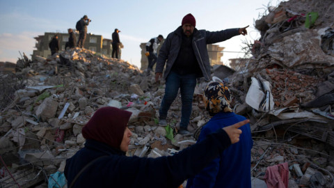 Local residents walk on the rubble of collapsed buildings as rescue workers continue the search for victims of the earthquake in Antakya, Turkey. Rescue crews on Saturday pulled more survivors, including entire families, from toppled buildings despite diminishing hopes as the death toll of the enormous quake that struck a border region of Turkey and Syria a week ago continue to rise.